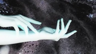 Dikey video. Olumsuz etki. Psikedelik enerji. Fantezi galaksisi. Mavi kadın uzaylı elleri koyu parlak baloncuk sıvısı mürekkep akışı hareket soyut arka plan çifte maruziyet.