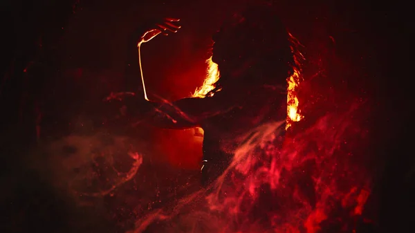 ファイヤーダンス ボディパフォーマンス 濃い背景のコピースペースの明るいスポットライトで赤い魔法の炎の煙で動く官能的な芸術的な女性のシルエット — ストック写真