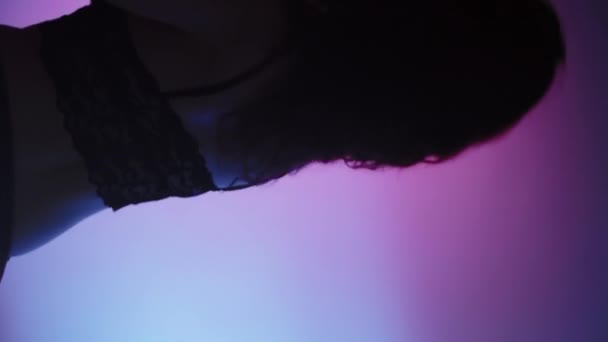 バーティカルビデオ 現代の振付 プロのダンス 紫のネオンライトの背景に移動する黒いレースのブラレットの優雅な官能的な芸術的な女性 — ストック動画