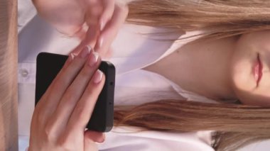 Dikey video. Cep telefonu işi. Sosyal medya pazarlaması. Modern akıllı telefon planlama stratejisi üzerine çevrimiçi uygulama yazan tanınmayan bir kadın.