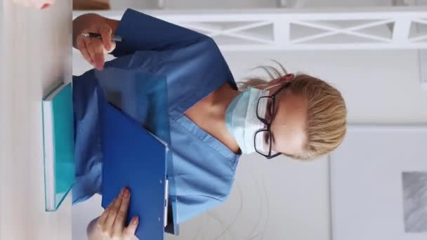 垂直ビデオ 医者の予約だ 健康診断 診療契約書にサインする女性専門医に薬を処方する女性 — ストック動画