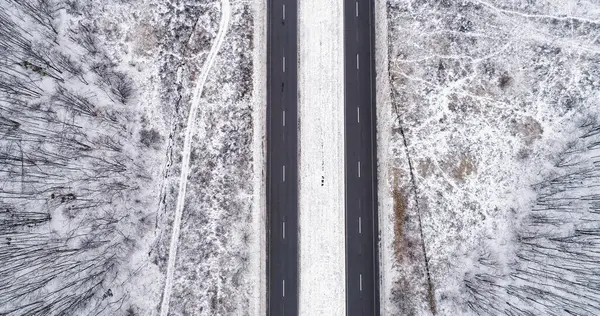 Hava karlı yolu. Kış manzarası. Beyaz donmuş orman ağacı asfaltlanmış yol bulutlu kırsal yol kaldırımı ile taçlandırılmış..