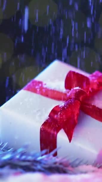 バーティカルビデオ クリスマスのお祝い ホリデーギフトコンポジション 驚くべき現在の箱は松の枝の赤いリボンの弓を包みました Xmas 装飾雪の魔法のライトの背景 — ストック動画