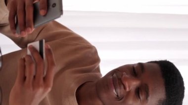 Dikey video. Gadget Bankası. Çevrimiçi ödeme. Para transferi. Faturaları ödeyen memnun bir adam. İnternetten alışveriş yapıyor. Evde kredi kartıyla..