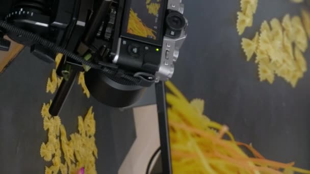 バーティカルビデオ 写真の舞台裏 シュートの準備 フォトスタジオで暗い表面に写真撮影のための小道具を置く認識できない女性 — ストック動画