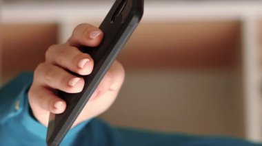 Dikey video. Gezici eğlence. Gadget teknolojisi. Akıllı telefon taraması yapan bir kadın çevrimiçi haber kaynaklarını kontrol ediyor..