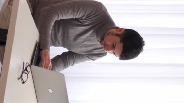 Dikey video. İş stresi. İş aşırı yüklendi. İşle ilgili. Öfkeli adam bilgisayarın kapanış belgelerini atıyor proje başarısızlığından rahatsız oluyor ofis işyerinde hatadan dolayı hayal kırıklığına uğruyor.