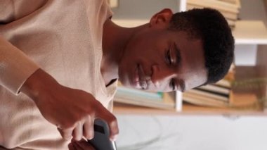 Dikey video. Gezici oyun. Gadget eğlencesi. Cihaz eğlencesi. Neşeli heyecanlı adam akıllı telefondan online esport uygulaması oynuyor evde dinlenmenin keyfini çıkarıyor..