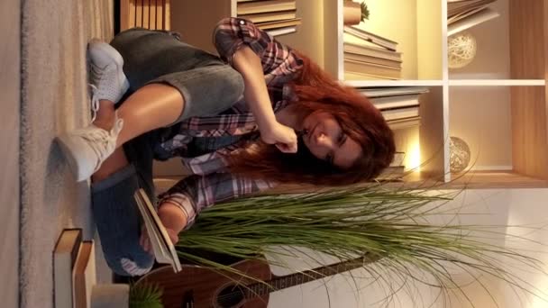 バーティカルビデオ 音楽インスピレーション 夢のような大人の女性 家で休憩する 軽い部屋の内部のノートを作るフロアリビングルームに座っているカジュアルな女性 — ストック動画