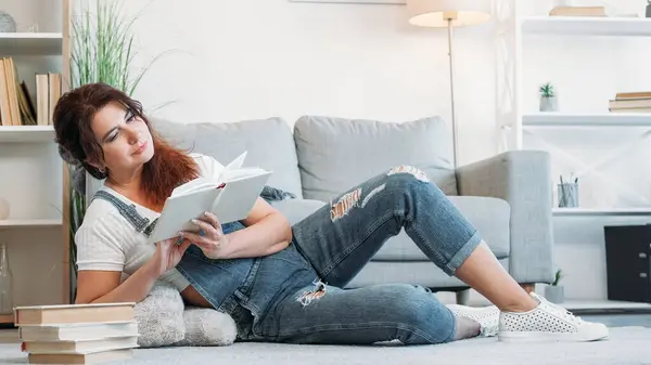 お気に入りの本 リラックスした女性 楽しい時間 家庭の床を敷き 軽い部屋の内部で読書するカジュアルな中年女性 — ストック写真