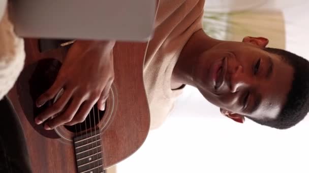 垂直ビデオ オンライン音楽学校 ギター教師 遠隔学習 自宅でノートパソコンのインターネットコールで文字列楽器のレッスンクラスを教える男 — ストック動画