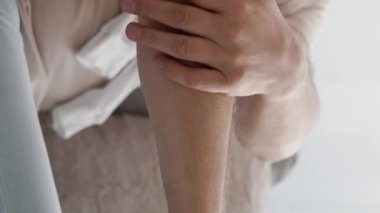 Dikey video. Eklem hastalığı. Kıdemli adam. Sağlık tedavisi. Tanımlanamayan yaşlı erkek masajcı eller dirsek koltukta oturuyor ev içi aydınlık.