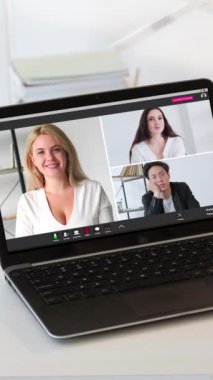 Dikey video. Uzaktan öğrenme. Çevrimiçi webinar. Çeşitli etnik çeşitlilikte erkek öğrenci grupları iş yerindeki koçla birlikte laptop ekranında sanal çağrı yapıyorlar..