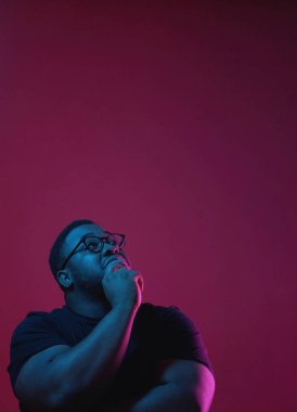 Karar veriyorum dostum. Planlar yarat. Düşünceli, düşünceli, çenesini tutarak yeni projeyi düşünen koyu pembe fotokopi arkaplanında izole edilmiş düşünceli bir adam..