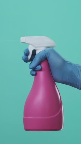 バーティカルビデオ 流動洗剤製品について 消毒衛生について 保護手袋の世帯の専門家の手緑の背景で隔離されたびんからの噴霧のクリーナー — ストック動画