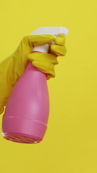 垂直录像 家政工具 卫生用品 洗涤剂设备 管理员手握粉红清洁剂喷雾瓶 戴防护手套 黄色底座隔离 — 图库视频影像