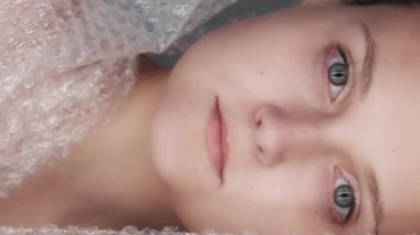 Dikey video. Plastik ambalaj. Atık yönetimi. Endişeli, düşünceli, gönüllü bir çevreci kadın biyolojik olarak çözülemeyen çöp poşeti geçmişi üzerine çalışıyor..