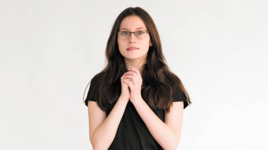 Heyecan verici bir beklenti. Şans dile. Gözlüklü, ilham verici bir kadın beyaz boş arka planda izole edilmiş, istenen sürprizi bekliyor..