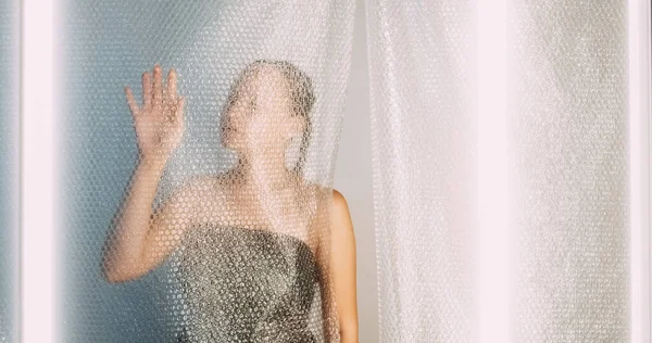 Plastik yeniden kullanım. Ekoloji problemi. Yumuşak kadın siluetinin dokulu çevresel atık azaltma sanatı baloncuk ambalaj duvarına dokunuyor boş alan.