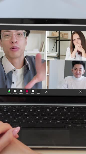 バーティカルビデオ オンラインウェブキャスト 遠隔コミュニケーション オフィスのラップトップスクリーンで話す興奮する同僚との仮想通話で多様な男性の女性ビジネスチーム — ストック動画