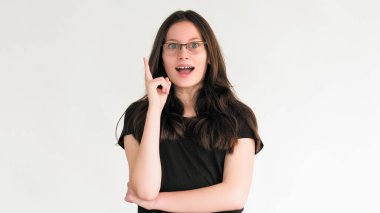 Fikir kavrayışı. Eureka çözümü. Hevesli, mutlu, gözlüklü, zeki bir kadın beyaz boş arka planda izole edilmiş bir yeri işaret ederek karar veriyor..