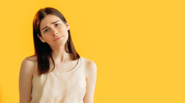 Hoşnutsuz ruh hali. Hayal kırıklığına uğradım. Zarif bluzuyla mutsuz bir yüz ifadesi olan üzgün güzel bir kadın turuncu arka planda izole edilmiş boş bir alanda..