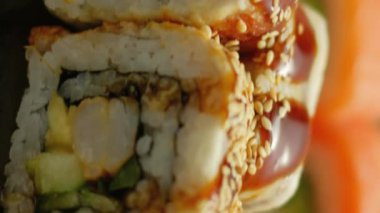 Dikey video. Suşi servisi. Yuvarlanma ayarlandı. Doğu mutfağı geleneksel Asya diyeti Japon yemekleri nefis restoranlarda lezzetlidir..