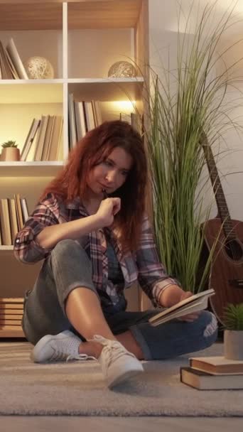 バーティカルビデオ 音楽インスピレーション 夢のような大人の女性 家で休憩する 軽い部屋の内部のノートを作るフロアリビングルームに座っているカジュアルな女性 — ストック動画