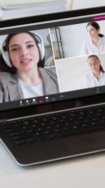 Dikey video. Çevrimiçi konuşma. Uzaktan işbirliği. Kurumsal kadın takım hevesli iş arkadaşı kulaklıkla sanal ofisteki laptop ekranında konuşuyor..
