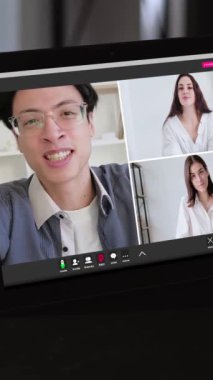 Dikey video. Takım çağrısı. Şirket telekomünikasyon. Heyecanlı adam, sanal ofisteki tablet ekranda kadın iş arkadaşlarıyla konuşurken fikir paylaşıyor.