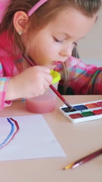 垂直录像 少年艺术家 创意休闲 小女孩在学校的桌子上用水彩画彩虹 并给有才华的孩子画上画笔 — 图库视频影像