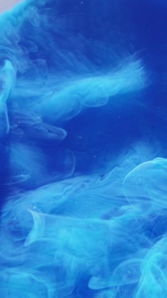 垂直录像 烟雾弥漫的云彩背景催眠式爆炸 蓝色墨水滴在水中的流动抽象了神秘的飘散在白色表面的空中的液体烟雾 — 图库视频影像