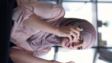 Dikey video. Sinir bozucu bir telefon. Telefon tartışması. Evdeki kötü haber servisinden rahatsız olup hücrede kavga eden sinirli bir kadın..