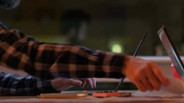 Ofis işleri. Şirket alanı. Erkek iş uzmanı dizüstü bilgisayarla konuşuyor iş arkadaşı bir kadınla telefonda konuşuyor akşam modern işyerinde belgelerle uğraşıyor..