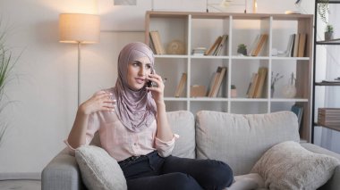 Mobil iletişim. Telefon var. Oturma odasında rahatla. Kadın hücrede konuşuyor rahat koltukta keyifli sohbetler ediyor modern iç mekanda..
