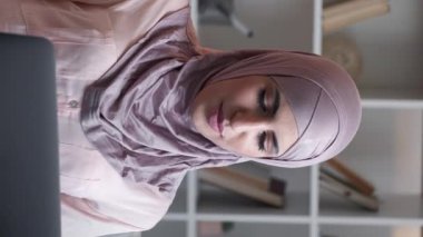 Dikey video. Laptop çağrısı. İnternet iletişimi. Çevrimiçi sohbet. Oturma odasındaki kanepede uzaktan internet konferansında gülümseyen kadın..