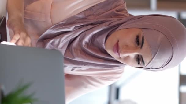 비디오 프리랜서 작동합니다 오피스 데스크탑 작업장에서 인터넷을 노트북에 히잡에 집중된 — 비디오
