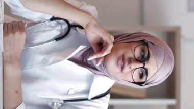 Dikey video. Çevrimiçi doktor. Sanal sağlık hizmeti. Teletıp danışmanlığı. Dost canlısı kadın doktor. Hastanedeki telefon görüşmesinde uzman tavsiyesi..