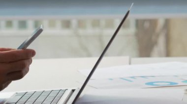 Ofis teknolojisi. Çevrimiçi sohbet. Erkek ve kadın meslektaşlar iş e-postalarını işyeri masasında dizüstü bilgisayar ve belgelerle birlikte satarak yazıyorlar..