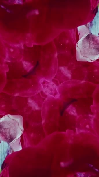 バーティカルビデオ 水中にペイントスプラッシュ カレイドスコープの装飾 ピンク色インク ライトブルーの抽象的な背景に対称的なデザインを広げる — ストック動画