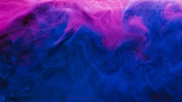 Color smoke. Ink water mix. Vapor floating. Blue pink neon glitter mist cloud texture abstract design copy space art background.