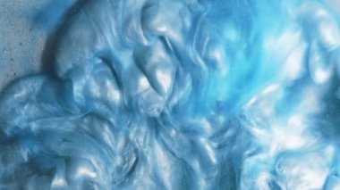 Parıltılı boya sıçraması. Mürekkep suyu. Patlama bulutu. Mavi renk, parlak sıvı, tahıl dokusu yüzeyinin soyut sanat arka planında akış hareketi yayıyor..