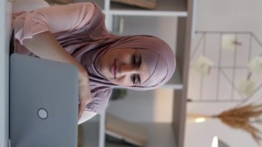 Dikey video. İnternet konferansı. Sanal koç. Çevrimiçi iletişim. Evde çalışan mutlu kadın bilgisayarlı uzaktan kumandalı ofis masasında toplantı çağrısı yapıyor..