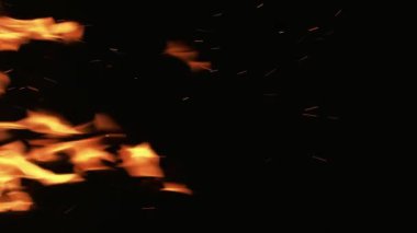Dikey video. Yangın arka planı. Siyah üzerine alev. Turuncu renkli ışık yanan şömine ısısı karanlık gece boşluğunda hareket kıvılcımına neden olur..
