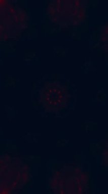 Dikey video. Ateş mandala. Kaleydoskop hareketi. Bulanık kırmızı turuncu parıltı, koyu mavi soyut arka planda çiçek simetrik süslemesini kıvılcımlar..