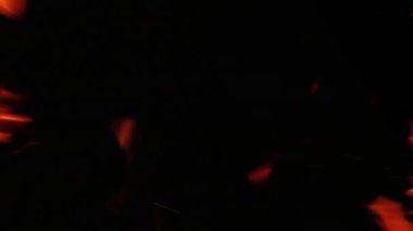 Dikey video. Yangın çerçevesi. Alev kıvılcımları. Yanan kaplama. Fotokopi uzayı ile siyah karanlık gece arkaplanı üzerinde turuncu kırmızı ışık sıcak alev parçacıkları.