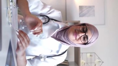 Dikey video. Doktor çevrimiçi danışma. Teletıp randevusu. İnternet sağlık hizmetleri. Hastane iş yerindeki sanal toplantıdaki kadın pratisyen..