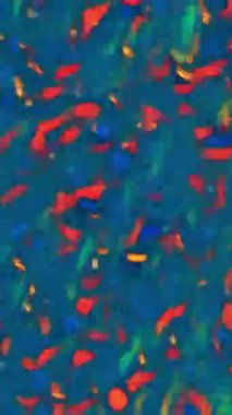 Dikey video. Renkli bir geçmiş. Görüntü kıvılcımlar saçar. Mavi soyut dokuda yoğunlaşmamış turuncu kırmızı parlayan parçacıklar kaotik akış.