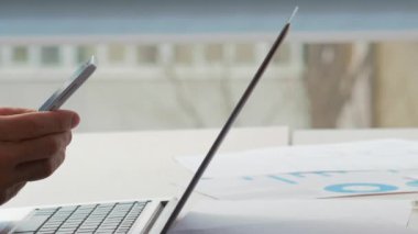Ofis teknolojisi. Çevrimiçi sohbet. Erkek ve kadın meslektaşlar iş e-postalarını işyeri masasında dizüstü bilgisayar ve belgelerle birlikte satarak yazıyorlar..