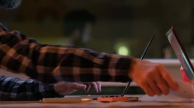 Ofis işleri. Şirket alanı. Erkek iş uzmanı dizüstü bilgisayarla konuşuyor iş arkadaşı bir kadınla telefonda konuşuyor akşam modern işyerinde belgelerle uğraşıyor..